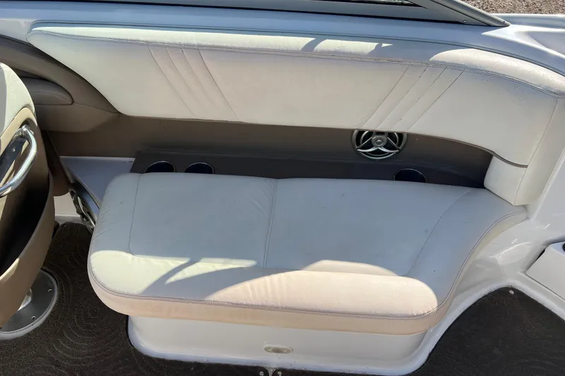 Slide: The Image of 2008 Cobalt 252 boat interior with white cushioned seating and cup holders. - 12