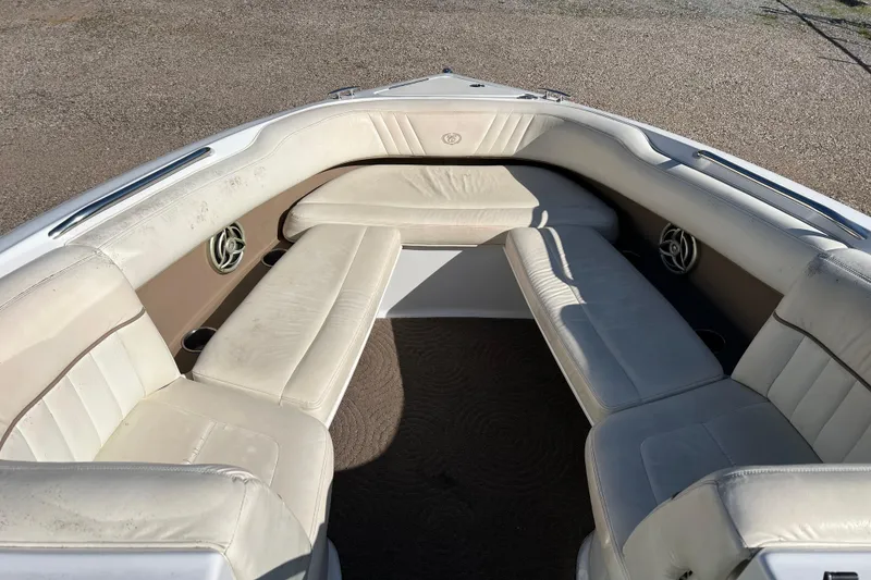 Slide: The Image of 2008 Cobalt 252 boat interior with white cushioned seating and built-in speakers. - 13