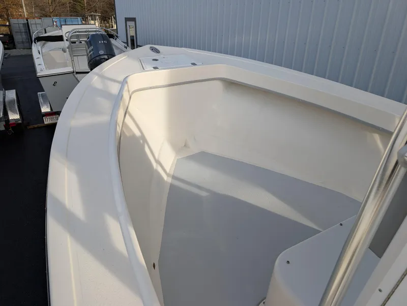 Slide: The Image of 2024 May-Craft 20 Cape Classic boat, white interior, docked near a metal building. - 10