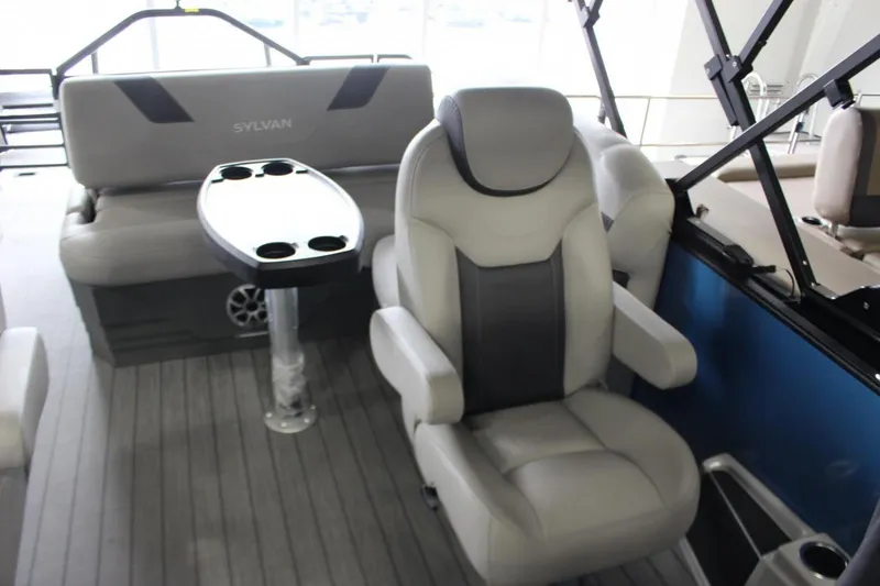 Slide: The Image of 2025 Sylvan L5 CLZ DH boat interior with plush seating and cupholder table. - 6