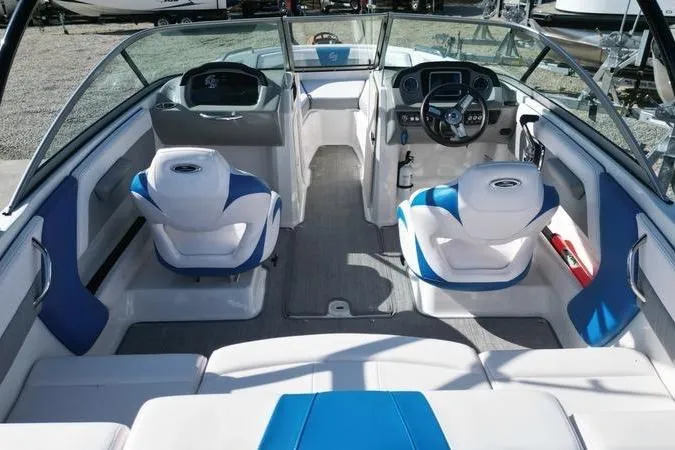 Slide: The Image of 2019 Chaparral 21 H2O Surf boat interior with blue and white seating and modern dashboard. - 12