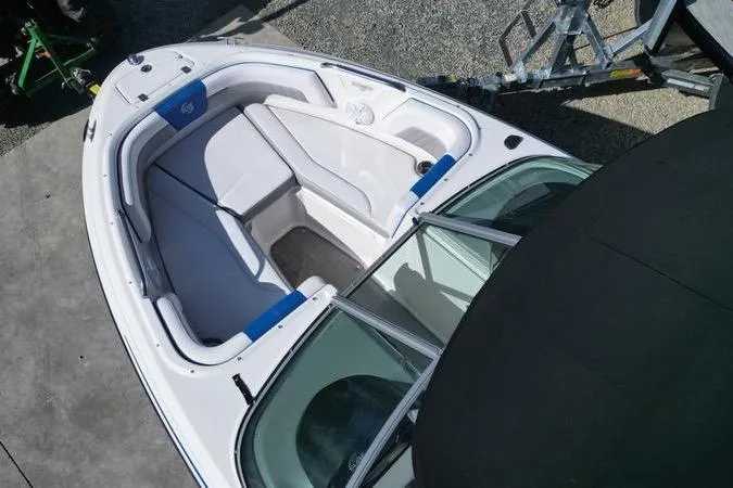 Slide: The Image of 2019 Chaparral 21 H2O Surf boat with vibrant blue and white design on trailer. - 17