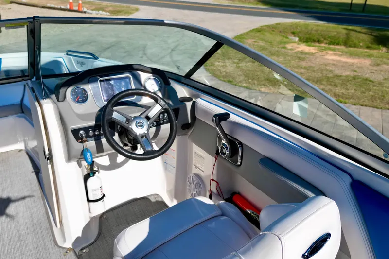 Slide: The Image of 2019 Chaparral 21 H2O Surf boat cockpit with steering wheel and dashboard controls. - 18