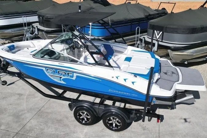 Slide: The Image of 2019 Chaparral 21 H2O Surf boat with blue and white design on a trailer. - 9
