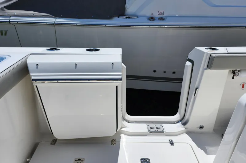 Slide: The Image of 2026 Pursuit S 328 Sport boat storage compartment with open lid and visible hardware. - 13