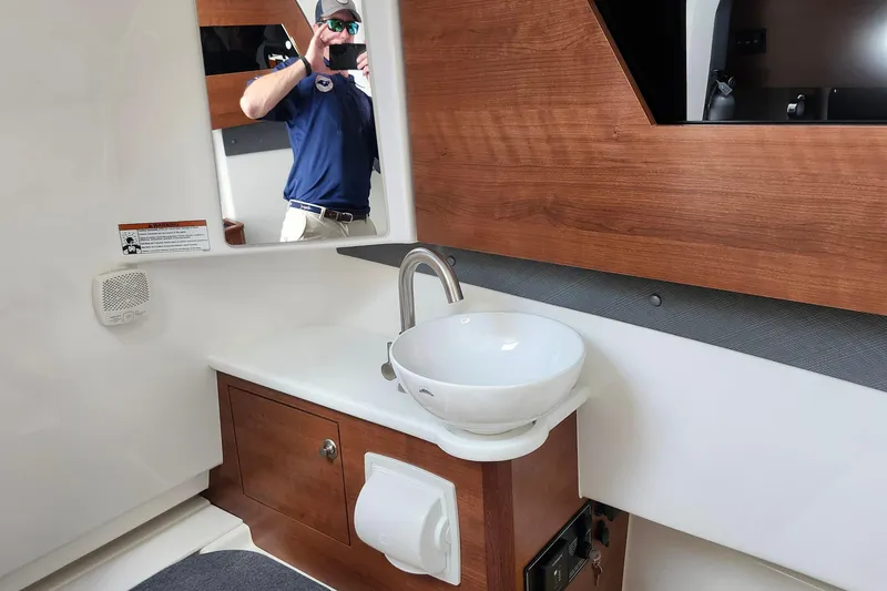 Slide: The Image of 2026 Pursuit S 328 Sport boat interior with cushioned seating and gray carpet. - 22