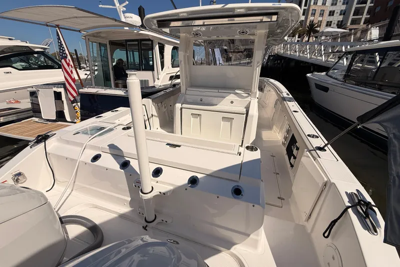 Slide: The Image of 2026 Pursuit S 328 Sport boat docked, showcasing spacious deck and modern design. - 43