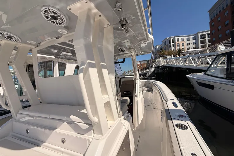 Slide: The Image of 2026 Pursuit S 328 Sport boat docked, showcasing sleek design and spacious seating. - 44