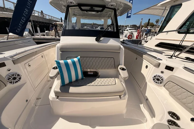 Slide: The Image of 2026 Pursuit S 328 Sport boat interior with cushioned seating and striped pillow. - 49