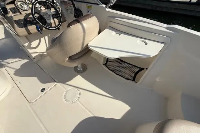 Slide: The Image of Interior of 2015 Bayliner 210 Deck Boat with steering wheel and seating. - 12