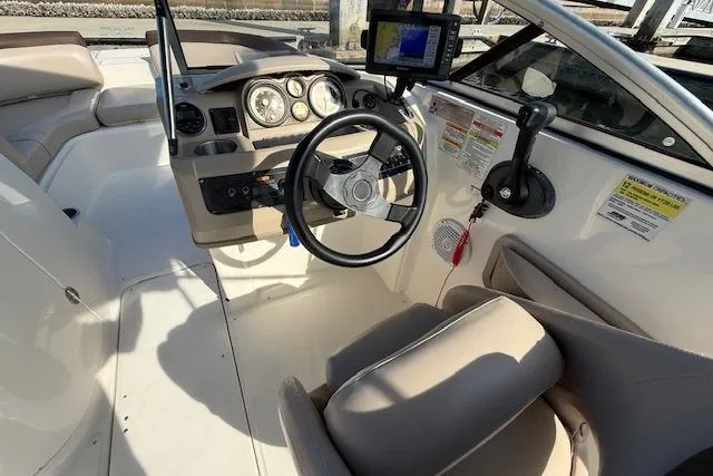 Slide: The Image of 2015 Bayliner 210 Deck Boat cockpit with steering wheel and navigation system. - 14