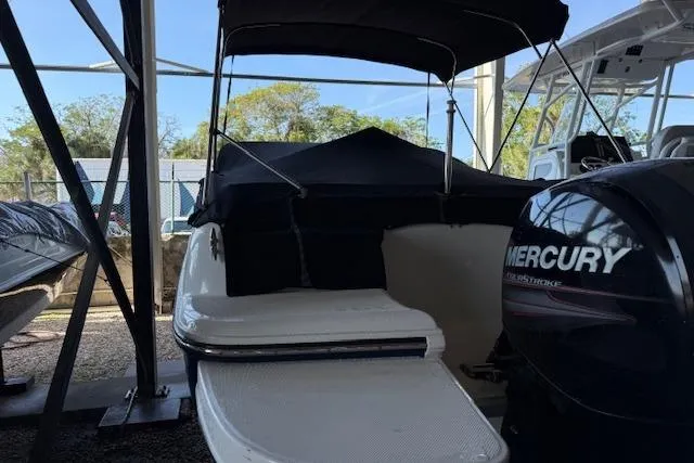 Slide: The Image of 2015 Bayliner 210 Deck Boat with Mercury engine, covered and docked in a marina. - 20