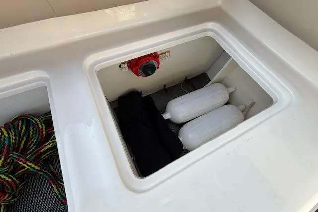 Slide: The Image of Storage compartment in a 2015 Bayliner 210 Deck Boat with ropes and fenders. - 22
