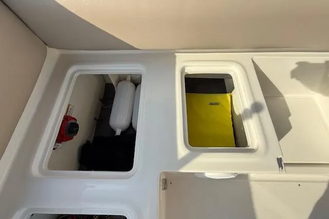 Slide: The Image of 2015 Bayliner 210 Deck Boat storage compartments with safety equipment and accessories. - 23