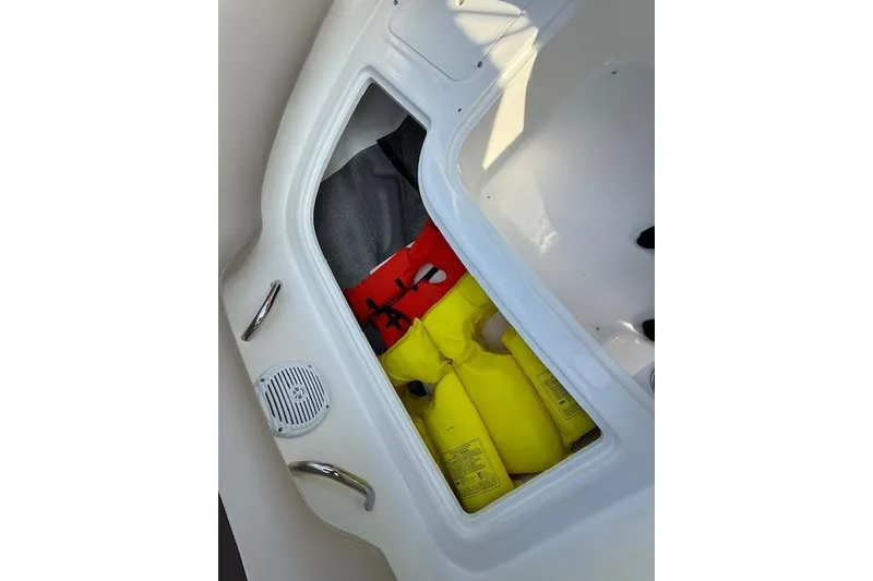 Slide: The Image of Storage compartment in a 2015 Bayliner 210 Deck Boat with life jackets. - 25