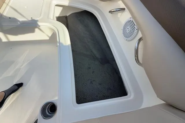 Slide: The Image of 2015 Bayliner 210 Deck Boat interior, featuring seating and storage area. - 26