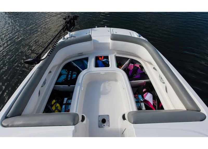 Slide: The Image of 2015 Bayliner 210 Deck Boat docked at marina, featuring spacious seating and canopy. - 4