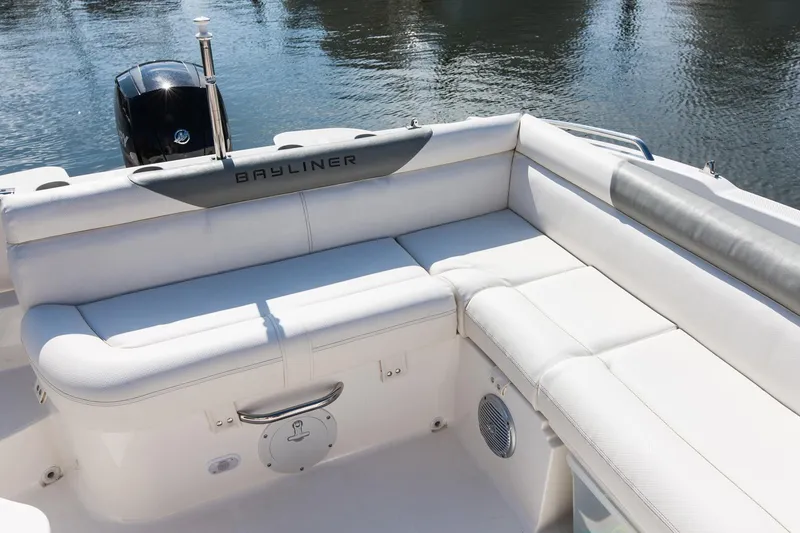 Slide: The Image of 2015 Bayliner 210 Deck Boat docked in a marina, featuring a sleek design and canopy. - 6