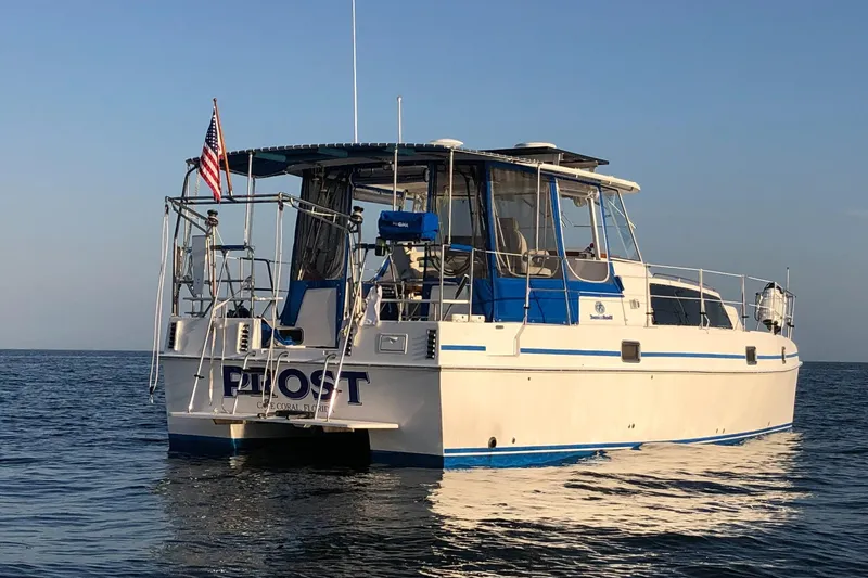 Slide: The Image of 2002 Endeavour Trawlercat 36 on calm water, rear view with American flag. - 1