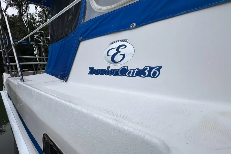 Slide: The Image of 2002 Endeavour Trawlercat 36 boat with blue canopy and logo on deck. - 17