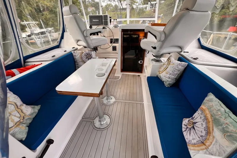 Slide: The Image of Interior of 2002 Endeavour Trawlercat 36 with blue seating, table, and helm chairs. - 20