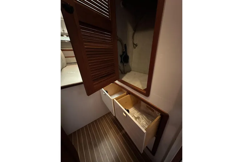 Slide: The Image of Interior of 2002 Endeavour Trawlercat 36 with open wooden cabinets and drawers. - 36