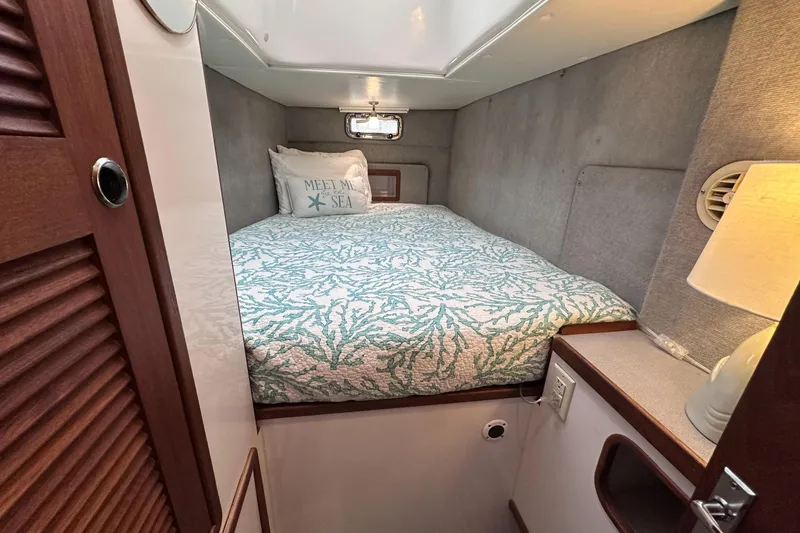 Slide: The Image of Cozy cabin interior of 2002 Endeavour Trawlercat 36 with nautical-themed bedding. - 41
