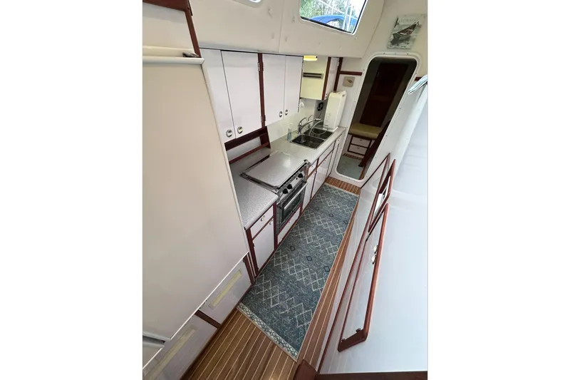 Slide: The Image of Interior of 2002 Endeavour Trawlercat 36, featuring a compact kitchen with modern amenities. - 45