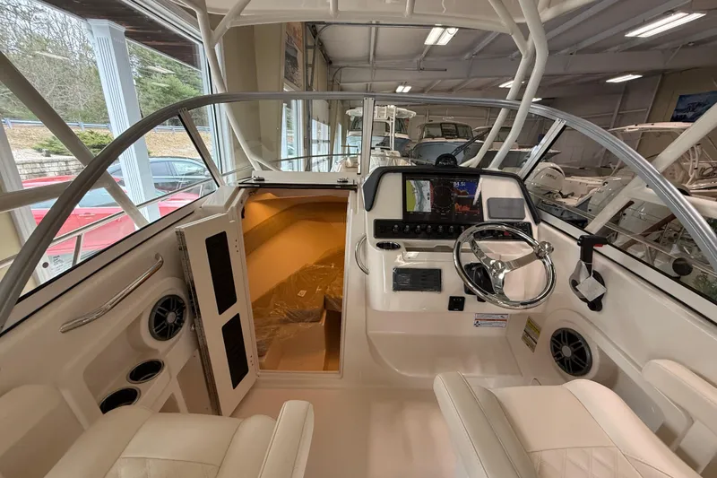 Slide: The Image of 2026 Grady-White Adventure 218 boat interior with steering console and cabin entrance. - 14