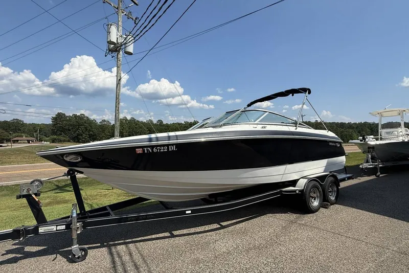 The Image of 2005 Cobalt 240 boat on trailer, parked outdoors under clear blue sky. - 1