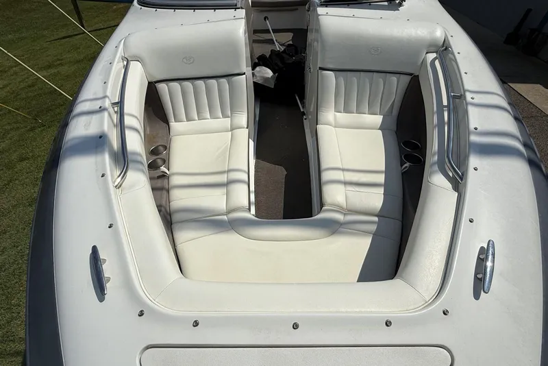 Slide: The Image of 2005 Cobalt 240 boat interior with white leather seating and cup holders. - 10