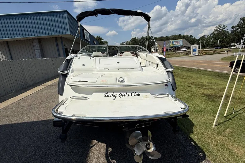 Slide: The Image of 2005 Cobalt 240 boat with "Lucky Girls Club" text, parked near a building. - 11