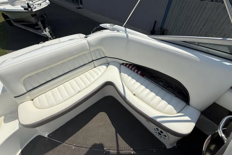 Slide: The Image of White leather seating on a 2005 Cobalt 240 boat, featuring cup holders and speaker. - 15