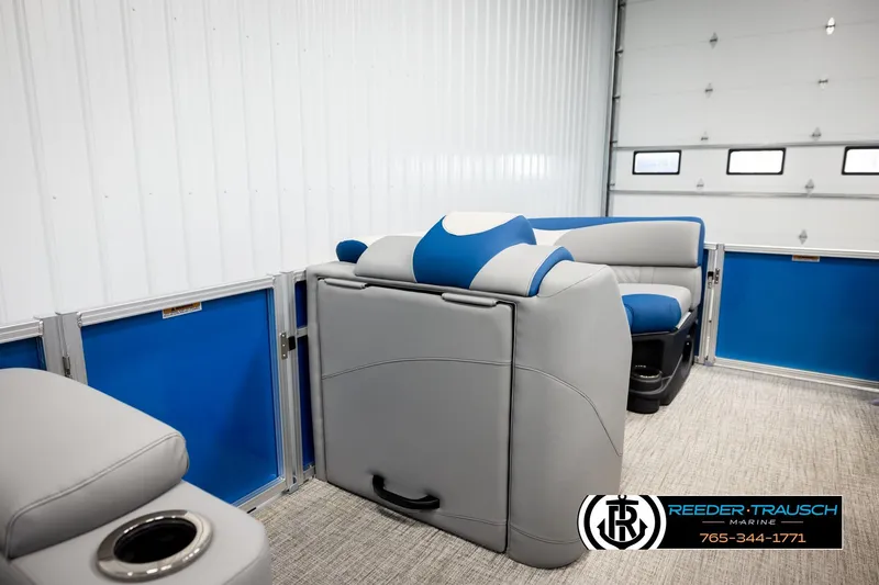 Slide: The Image of 2026 Avalon LSZ Vrl boat interior with blue and gray seating, Reeder-Trausch Marine logo. - 27