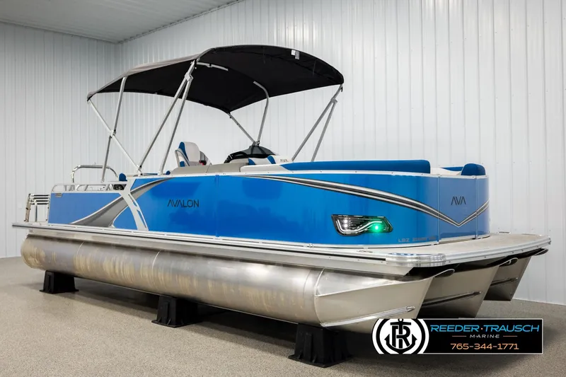 Slide: The Image of 2026 Avalon LSZ Vrl pontoon boat in showroom, blue exterior, black canopy. - 3