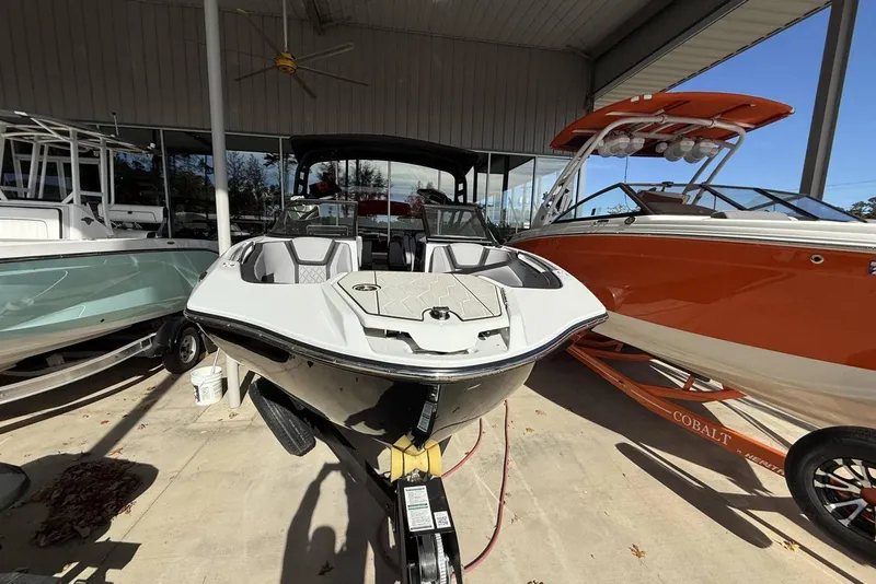 Slide: The Image of 2024 Yamaha Boats 255XD displayed in a showroom, surrounded by other boats. - 11