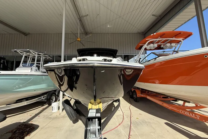 Slide: The Image of 2024 Yamaha Boats 255XD in showroom, flanked by other boats, front view. - 12