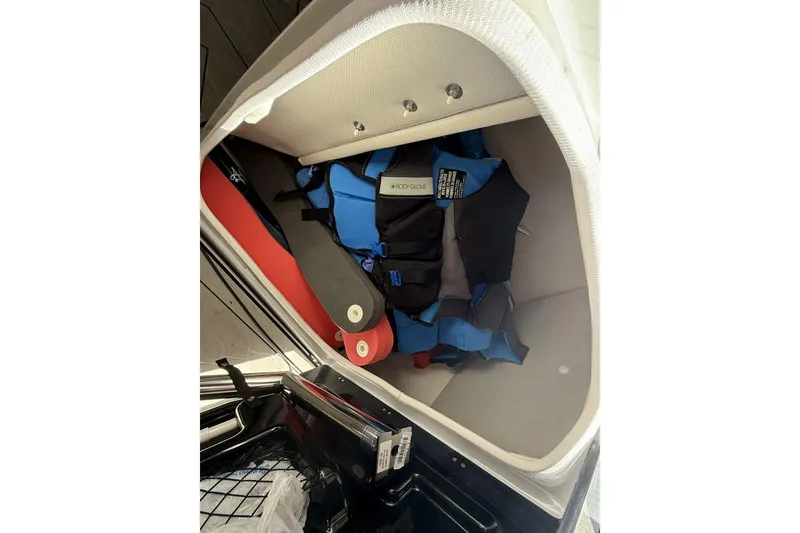 Slide: The Image of Storage compartment in 2024 Yamaha Boats 255XD with life jackets and safety gear. - 13