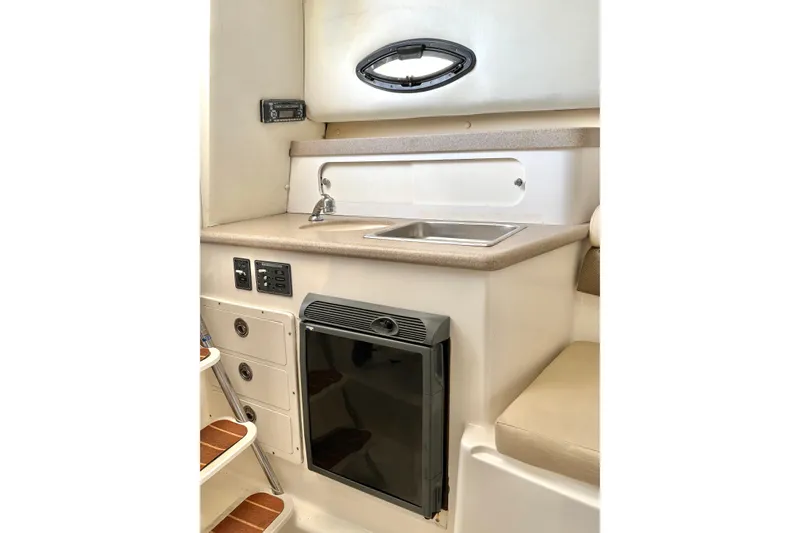 Slide: The Image of 2006 Century 2400 Walkaround boat interior with kitchenette, sink, and storage. - 23