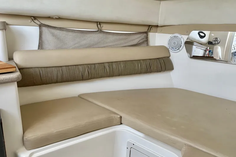 Slide: The Image of 2006 Century 2400 Walkaround cabin interior with beige seating and storage net. - 28