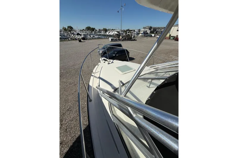 Slide: The Image of 2006 Century 2400 Walkaround boat in marina, showcasing deck and railing. - 3