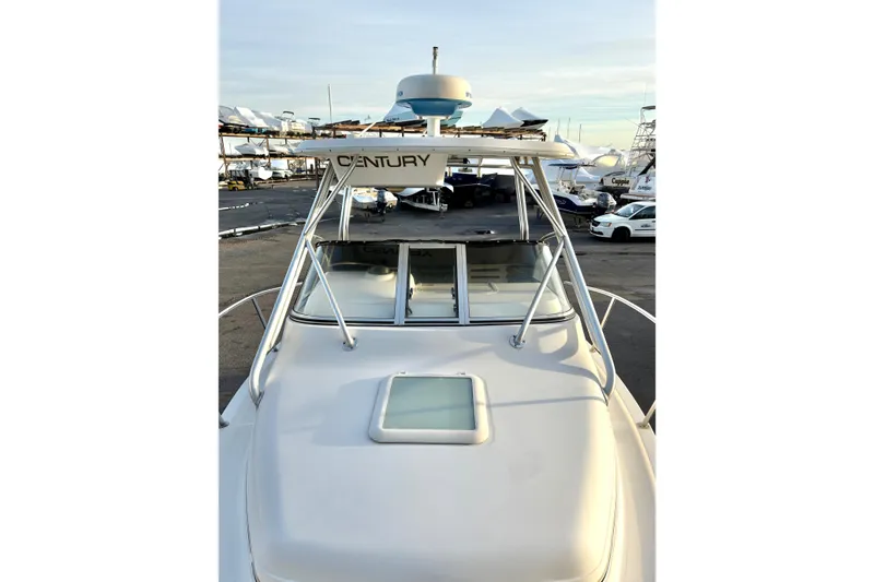 Slide: The Image of 2006 Century 2400 Walkaround boat docked, showcasing front deck and cabin. - 5