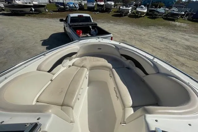 Slide: The Image of 2001 Chaparral 230 SSi boat with spacious seating, parked near a pickup truck. - 12