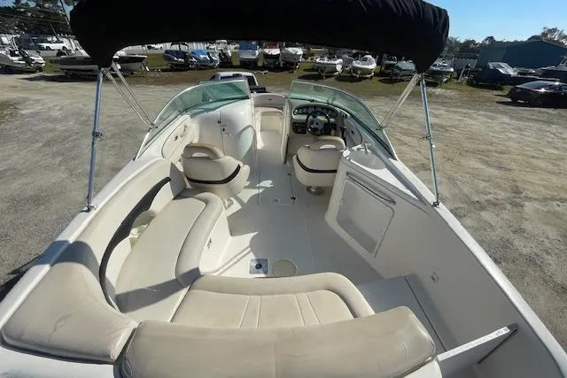 Slide: The Image of 2001 Chaparral 230 SSi boat interior with seating and steering wheel, parked outdoors. - 13