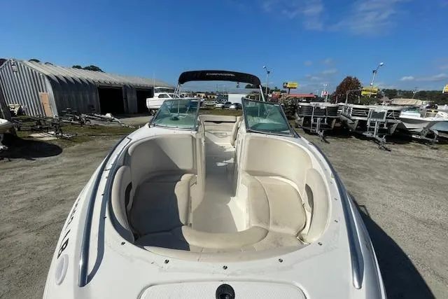 Slide: The Image of 2001 Chaparral 230 SSi boat with open bow seating, parked outdoors under clear skies. - 14