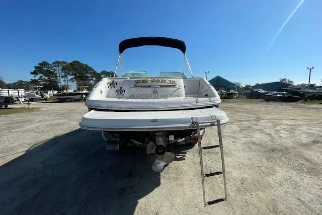 Slide: The Image of 2001 Chaparral 230 SSi boat with ladder, parked on gravel lot under clear blue sky. - 3