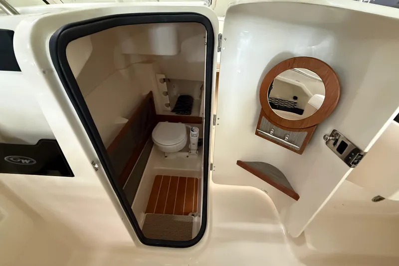 Slide: The Image of Interior of 2026 Grady-White Freedom 275 boat, featuring a compact bathroom with mirror. - 16