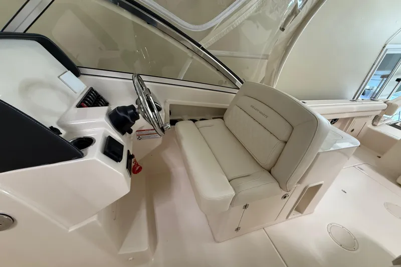 Slide: The Image of 2026 Grady-White Freedom 275 boat interior with steering wheel and seating. - 17