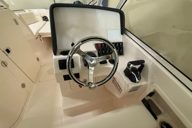 Slide: The Image of 2026 Grady-White Freedom 275 boat helm with steering wheel and controls. - 18