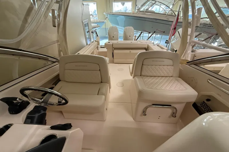 Slide: The Image of 2026 Grady-White Freedom 275 boat interior with luxurious seating and steering wheel. - 23